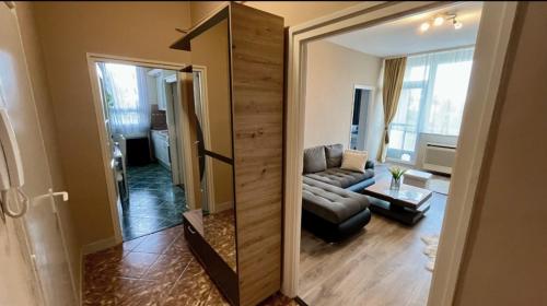 a view of a living room with a couch and a mirror at Jucus Apartman in Makó