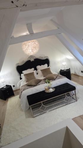 a bedroom with a large bed with a black headboard at Le cocoon de choupette in Cuvilly