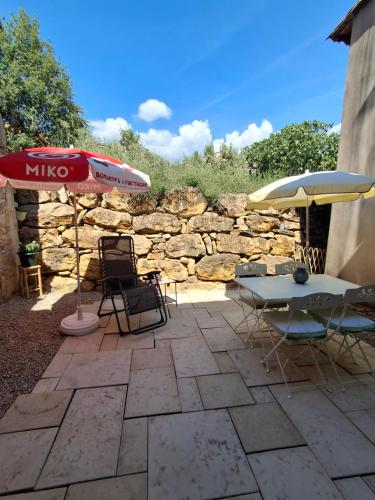 a patio with a table and an umbrella and chairs at Casa Doudou in Bédoin