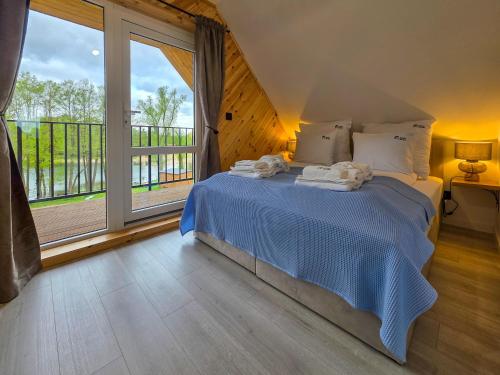 a bedroom with a bed and a large window at Zatoka Warmii in Tomaszkowo