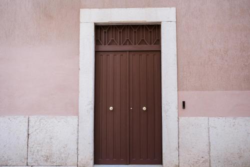 a brown door in a pink and white wall at MEANDRI Apartment in San Severo