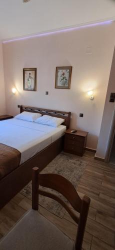 a bedroom with a bed and a chair in it at Simos in Vrontádos