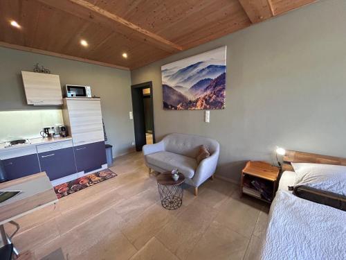 a room with a bed and a chair and a table at FeWo Marielle in Seeboden