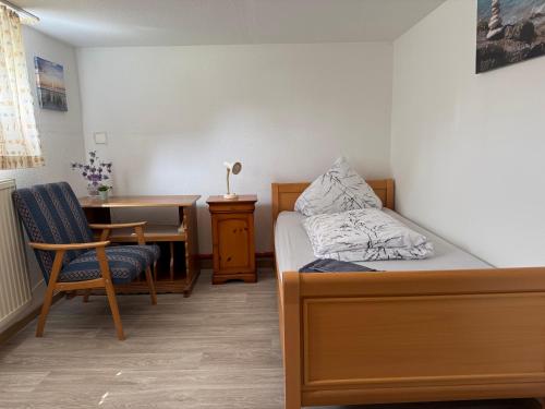 a bedroom with a bed and a desk and a table at Van Kim 2 - Souterrain Monteurwohnung in Emden