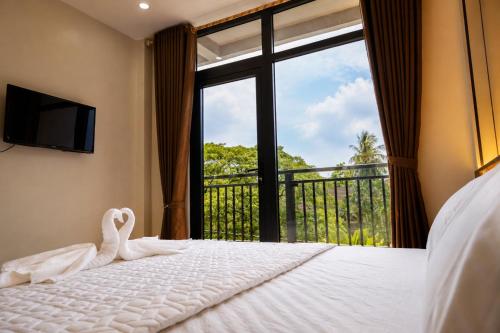 a bedroom with a swan on a bed with a window at Lucky Hostel in Vientiane