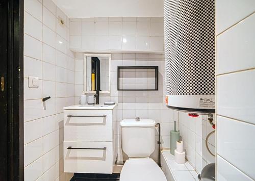 a white bathroom with a toilet and a sink at 17m2 Flower studio dans le centre historique Ecusson in Montpellier