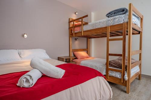 a bedroom with two bunk beds and a red blanket at Me Gusta Sucre Inn in Sucre