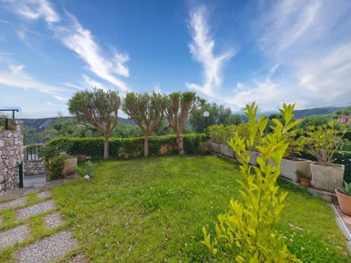 a garden with grass and trees on a hill at Rivierarent Il Giardino Del Navigatore in Finale Ligure