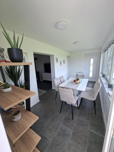 a living room with a dining room table and chairs at KUĆA za odmor 128 in Plešivica