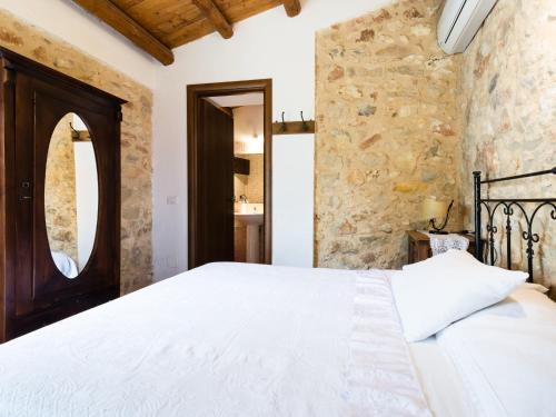 a bedroom with a bed and a stone wall at A Lumia in Noto