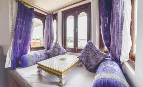 a couch in a room with purple curtains and a table at hotel sargam sadan in Jāmb