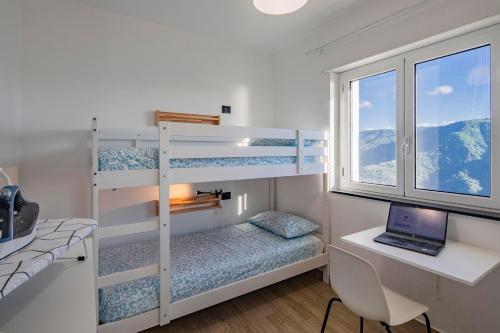 a bedroom with bunk beds and a desk with a laptop at Caliante in Piraino