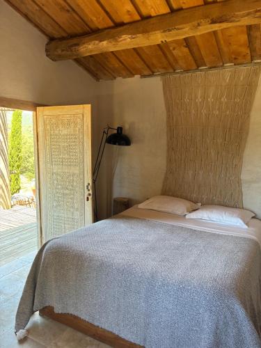 a bedroom with a bed with a wooden ceiling at Chambre bergerie privée in Sartène