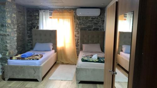 two beds in a small room with a window at Natura Koman in Koman