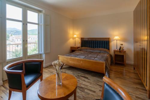 a bedroom with a bed and a table and chairs at Hotel Certosa in Padula