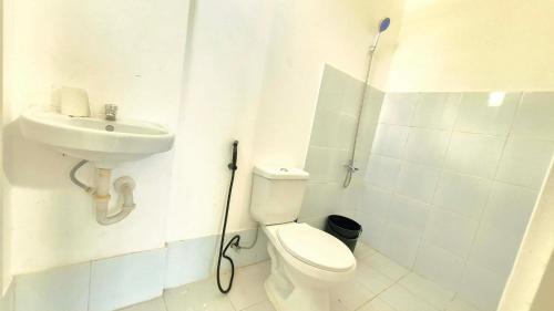 a white bathroom with a toilet and a sink at Phirst Park Homes Baliwag in Baliuag