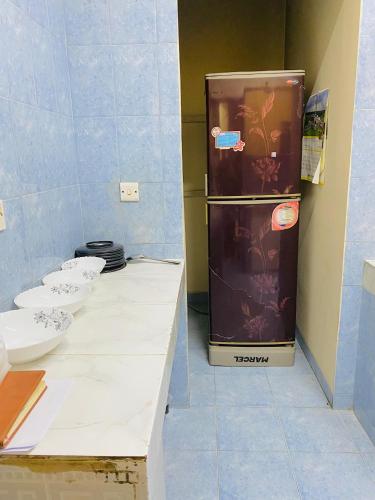 eine Küche mit drei Spülbecken und einem Kühlschrank in der Unterkunft ADD Eden in Dhaka