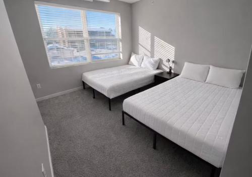 a bedroom with two beds and a window at Olive Oasis in Des Moines