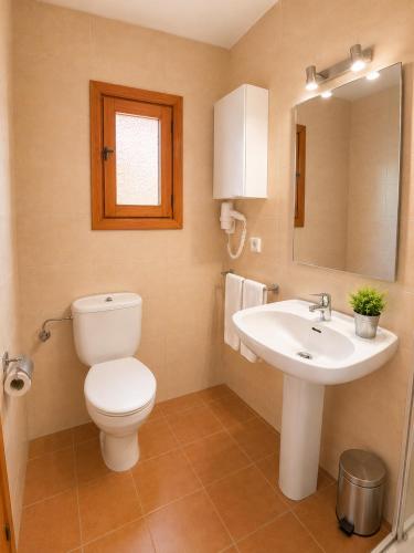 a bathroom with a toilet and a sink at Can Joan Robert des Mestre in Es Caló