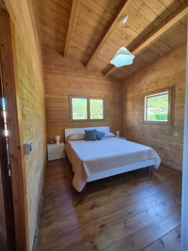 a bedroom with a bed in a wooden cabin at La Baita Del Bosco in Albano di Lucania