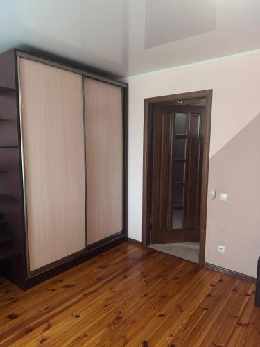 an empty room with sliding glass doors and wooden floors at Затишні апартаменти Східна Перлина in Vinnytsya