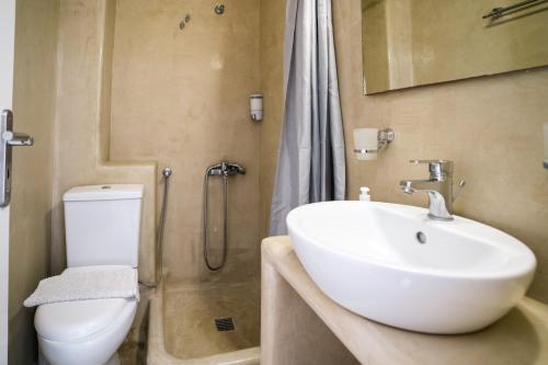 a bathroom with a white sink and a toilet at Kamarela Studios in Kamari