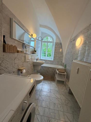 a white bathroom with a sink and a toilet at Gipfelglück Sebnitz Apartment in Sebnitz