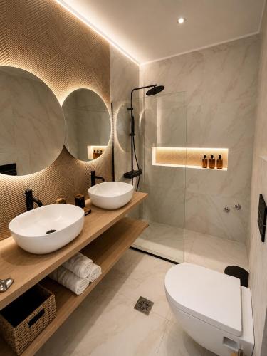 a bathroom with two sinks and a shower at Euphoria Suites and Studios in Sidari