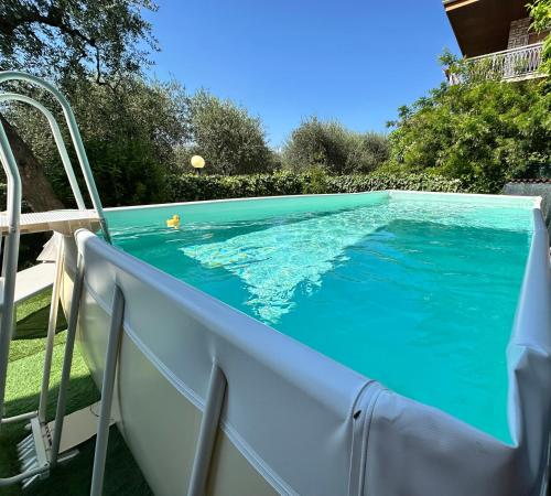 a swimming pool with a table and chairs next to it at Villalvento in Brenzone sul Garda