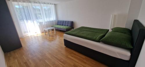 a bedroom with a bed with green sheets and a chair at Time Out 13 in Ohlsdorf