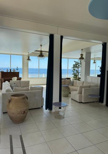 a large living room with couches and a view of the ocean at Hotel Ariana in Marine du Miomo