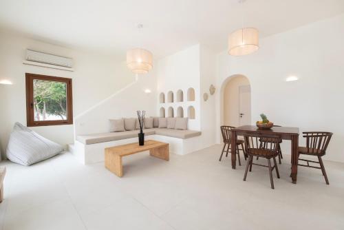 a white living room with a table and chairs at the shelter - a milos project in Adamantas