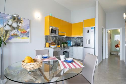 a kitchen with a glass table with a bowl of fruit on it at In Tenerife, luxury apartment overlooking the Atlantic in Bajamar