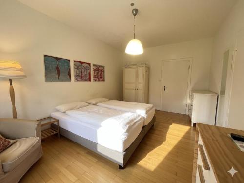 a bedroom with a white bed and a couch at Moderne Ferienwohnung Deichstrasse in Hennef
