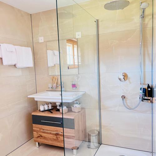 a bathroom with a sink and a shower at Chalet Mountain Lodge in Kandersteg