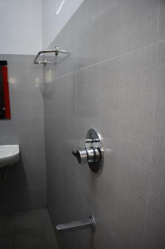 a shower stall in a bathroom with a sink at Hotel KGR in Palni