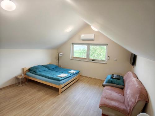 a room with a bed and a couch and a window at Apartament Bliżej Nieba in Bącza