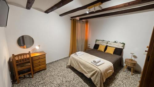 a bedroom with a bed and a dresser and a television at Albergue La Cuba in La Cuba