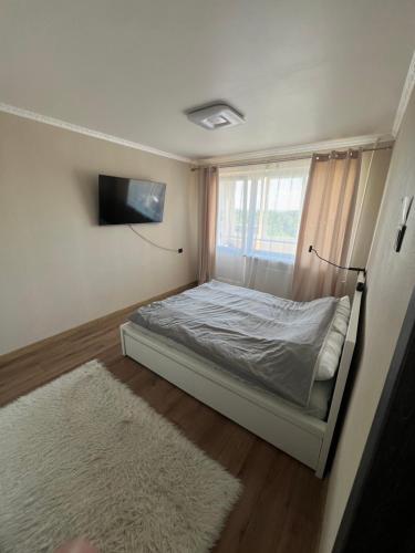 a small bedroom with a bed and a window at Deividas apart in Vilnius