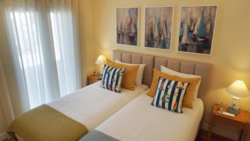 a bedroom with a bed with pillows on it at Paradisus III in São Martinho do Porto