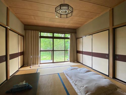 a bedroom with a bed and a large window at ロッジ星の時間 Lodge in Hokuto