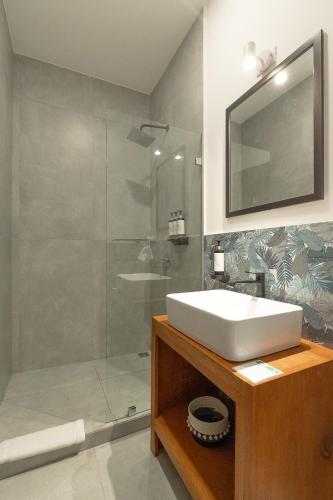 a bathroom with a white sink and a shower at Wide Mouth Frog Quepos in Manuel Antonio