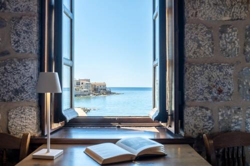 Meerblick von einem Tisch mit Büchern und einer Lampe in der Unterkunft Pyrgoi Theodorakaki: O Gerolimenas in Yerolimin