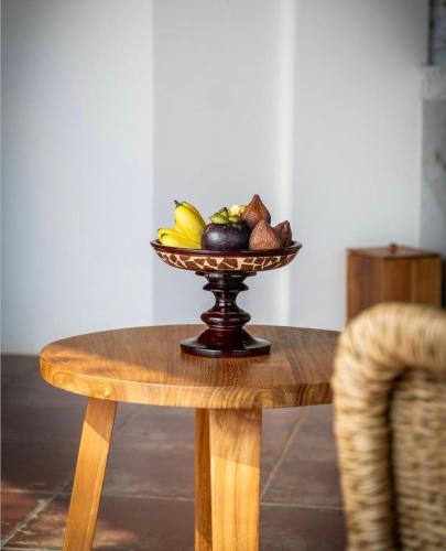 a bowl of fruit on a wooden table at The Scape Valley Villas in Tampaksiring
