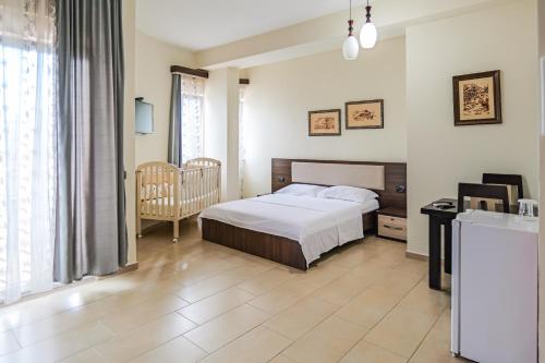 a bedroom with a bed and a chair in a room at Hotel Alba in Shëngjin