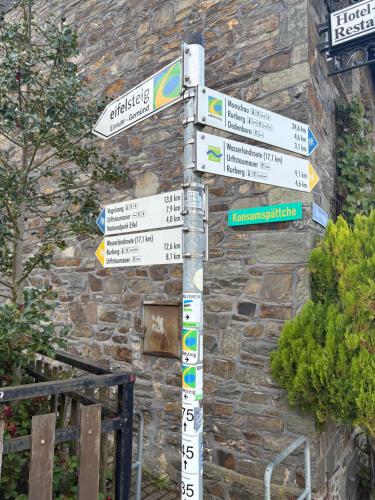 a pole with street signs in front of a building at Am Obersee Hotel in Simmerath