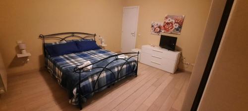 a bedroom with a bed and a dresser and a television at Dimora Lo Zizzolo - Casa vacanze indipendente vicino Pontedera in Pontedera