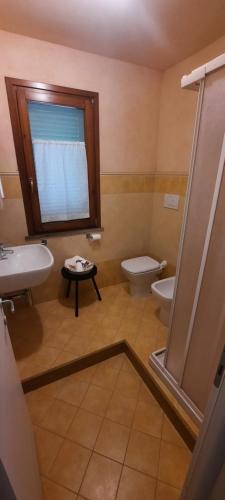 a bathroom with a sink and a toilet and a window at Dimora Lo Zizzolo - Casa vacanze indipendente vicino Pontedera in Pontedera
