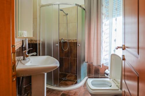 a bathroom with a shower and a sink and a toilet at Hotel Alba in Shëngjin
