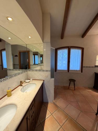 a bathroom with two sinks and a large mirror at Villa La Giulia in Cerveteri